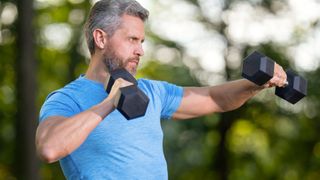 man doing dumbbell workout outside