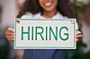 Person holding a sign that says hiring.