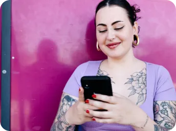 Une femme regarde son appareil mobile en riant tout en discutant sur WhatsApp